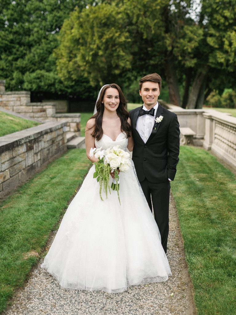 Sophisticated siblings portrait capturing a smiling brother and sister during an upscale outdoor estate wedding celebration