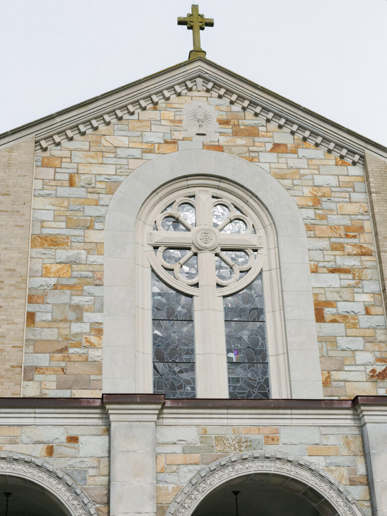 Grand Aldrich Mansion wedding chapel exterior highlighting a stunning large round rose stained glass window and stone brick facade