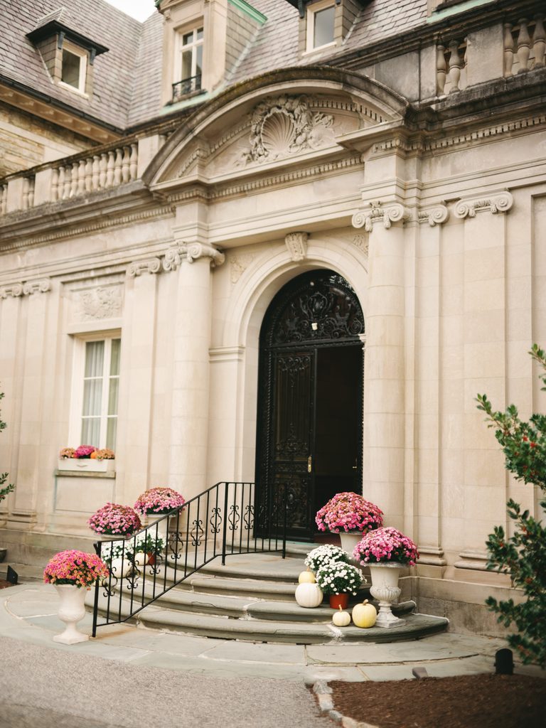 Grand Aldrich Mansion wedding venue exterior showcasing the historic stone entrance with elegant black wrought iron doors