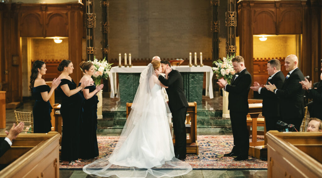 Luxury indoor wedding ceremony inspiration featuring a traditional chapel setting with a majestic wooden altar and elegant white floral arrangements