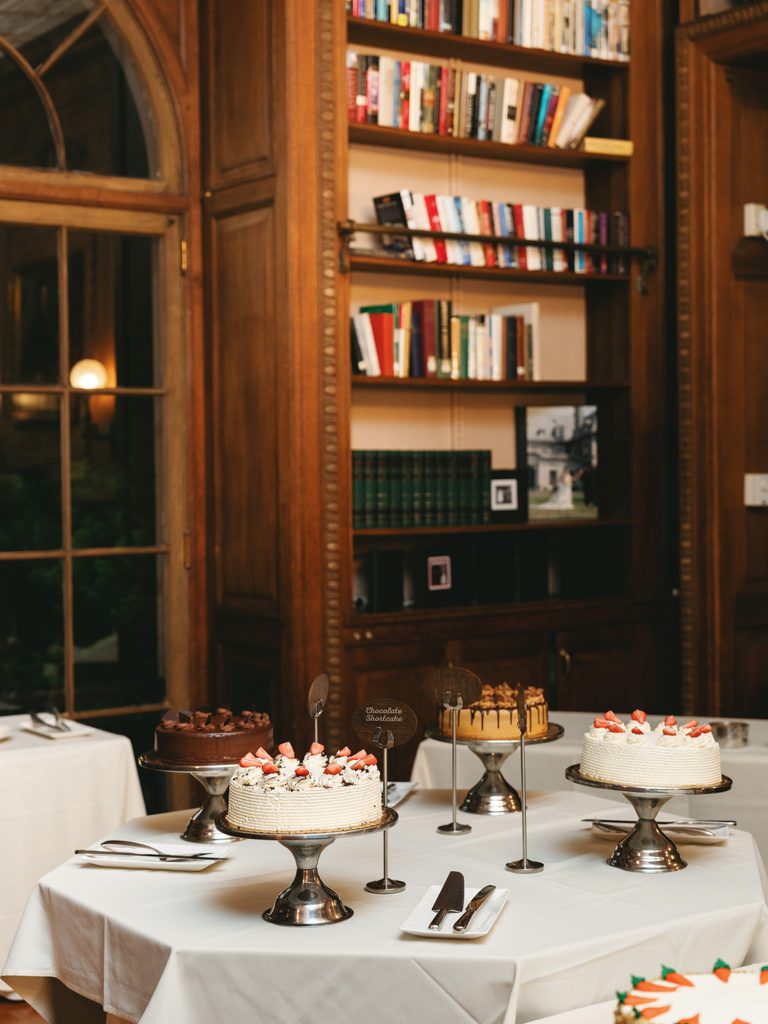Delicious dessert bar selection during an Aldrich Mansion wedding reception displaying various artisan cakes on silver stands
