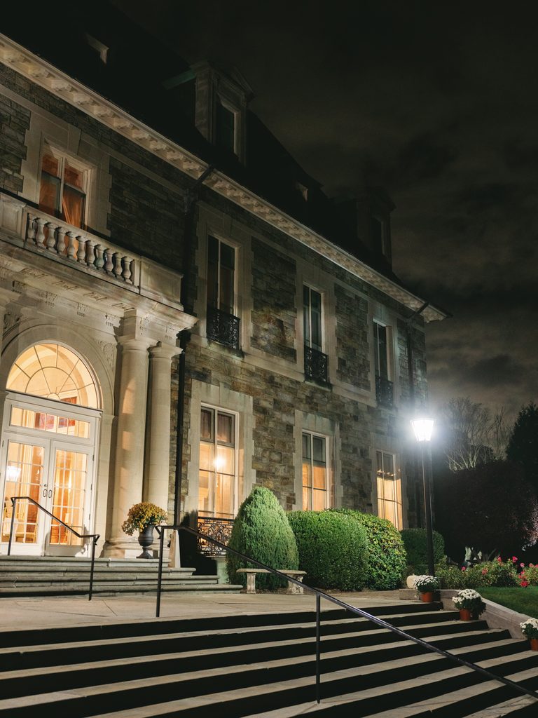 Illumined Aldrich Mansion wedding venue exterior showcasing the grand historic stone estate architecture illuminated at night