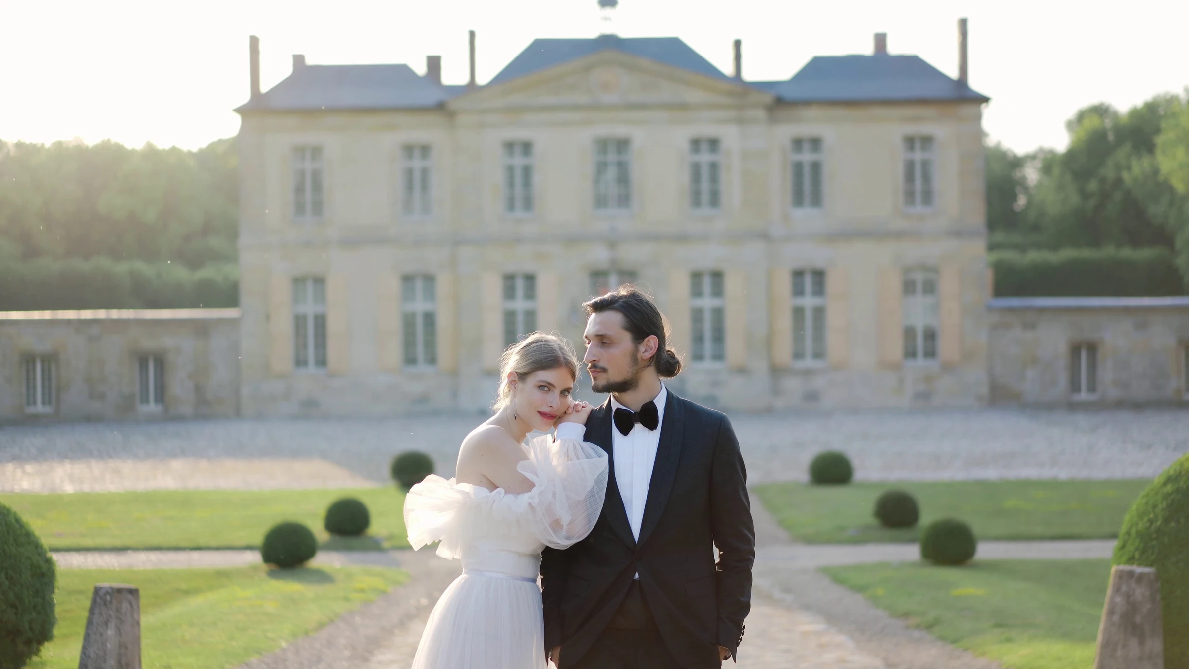 A wedding couple in the gardens of a chateau